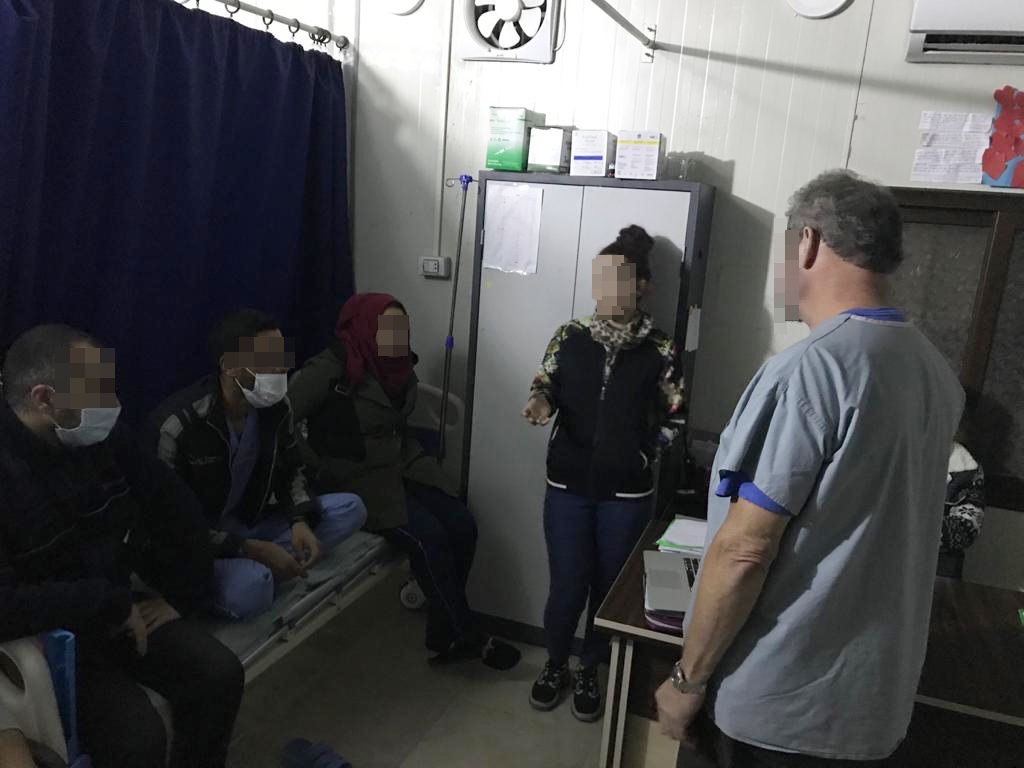 Three people sit on a patient bed in the hospital and listen to the lecturers' statements.