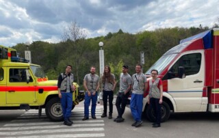 Ein medizinisches Team von CADUS zwischen zwei Rettungswagen.