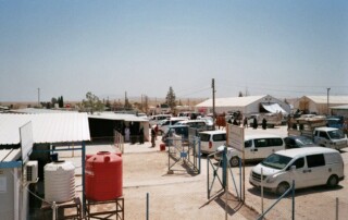 Overview over the camp from the roof of the field hospital. To the left some PHC stations from other organizations, to the right warehouses. In the middle the main road to the entrance.